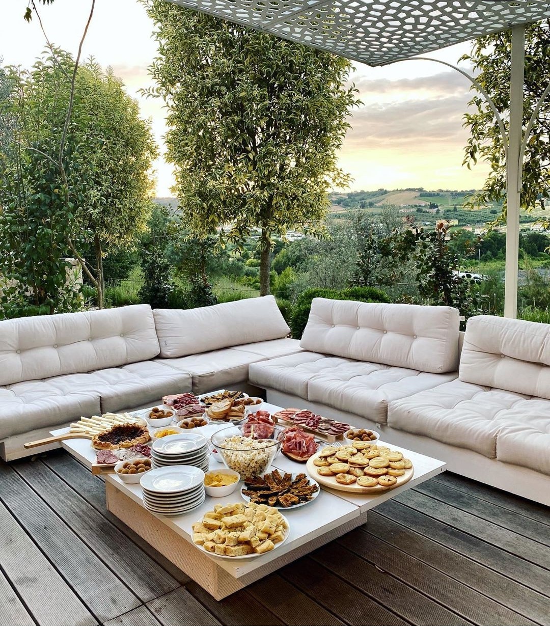 Aperitivo spread on the outdoor sofa at sunset