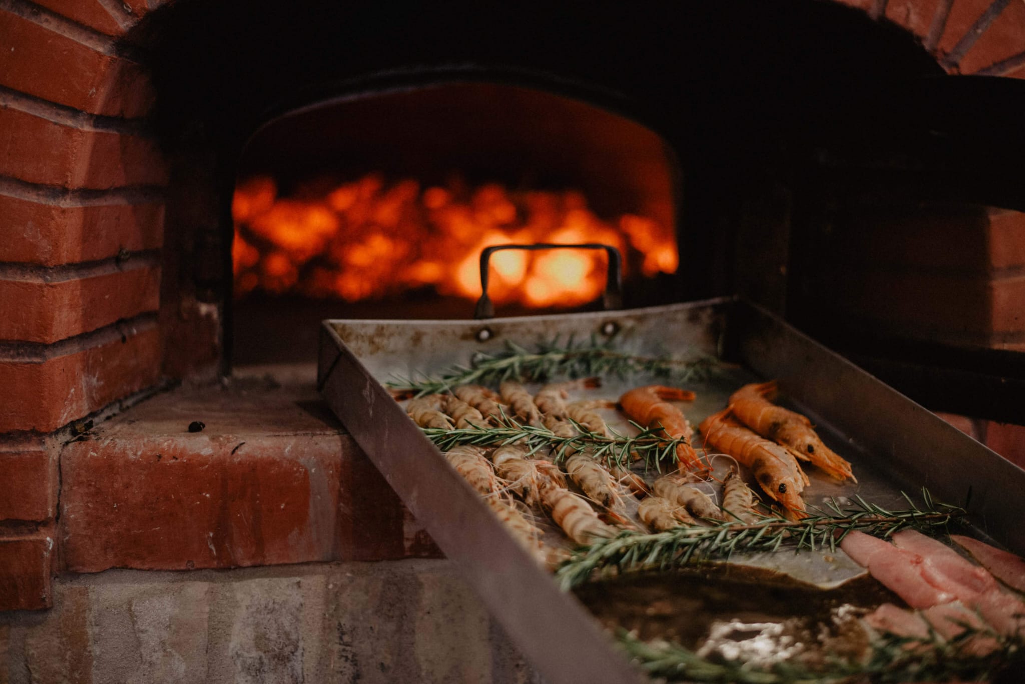 Prawns roasting with rosemary in the wood oven
